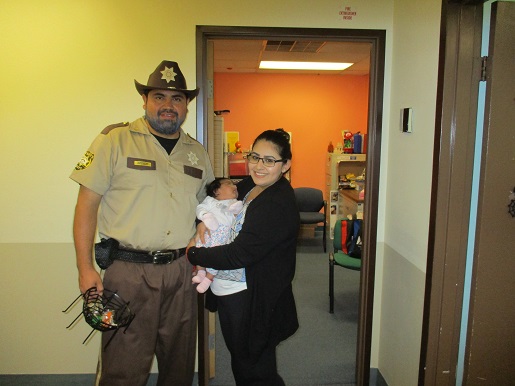 Luis standing next to Nancy and her baby